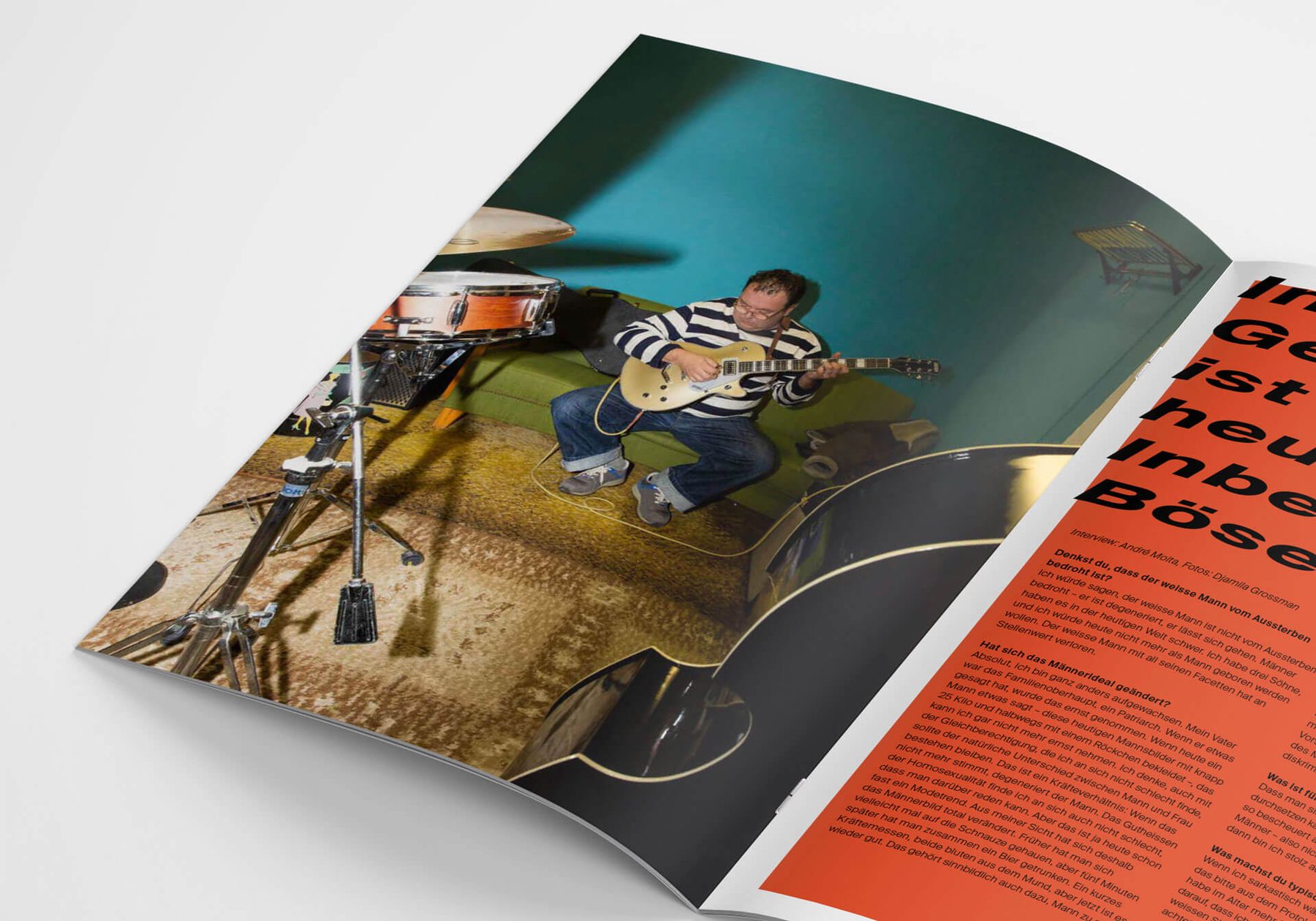 An open spread of the magazine: a portrait of a man playing guitar beside a bold red interview page